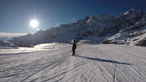 Skifahren in den Alpen im Winter. Ein Mann rollt auf einem Snowboard auf den schneebedeckten Pfaden eines Berges