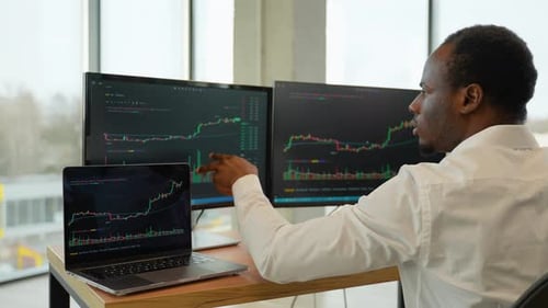 Fokussierter Crypto Trader-Analyst betrachtet den Computerbildschirm und analysiert Börsendiagramme