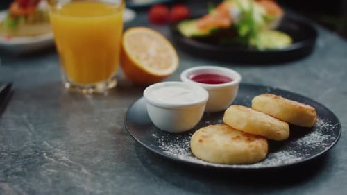 Restaurant Breakfast with a Plate of Cheesecake and Orange Juice on the Table