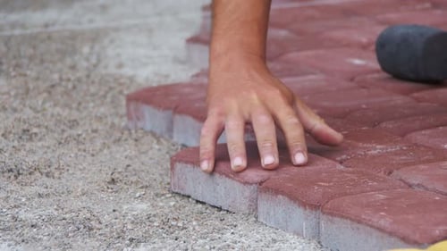 The Builder is Laying Paving Stones
