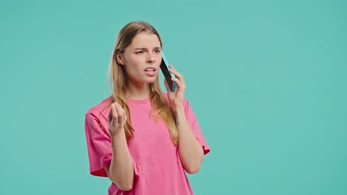 Frustrated Young Woman Talking on Smartphone