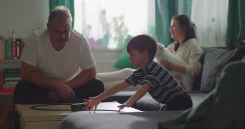 Family Relaxing at Home with Child Playing with Toy