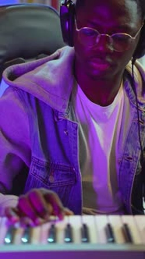 Young Adult Playing Electronic Keyboard in Studio