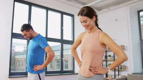 Sport, Fitness, Lifestyle and People Concept - Smiling Man and Woman Exercising