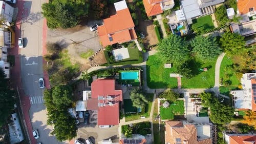 House with a swimming pool on a residential street, aerial top down