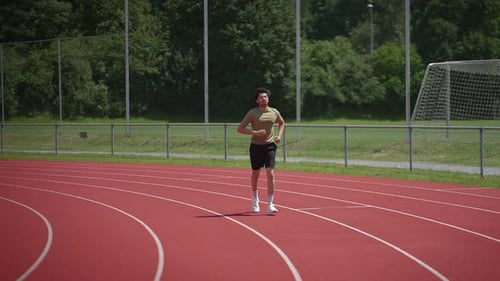Young Adult Male Running on a Track