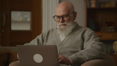 Senior Man Using Laptop Computer at Home