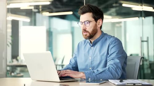 Man Working at Laptop in Modern Office