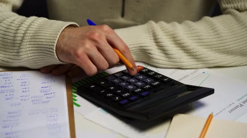 Homme analysant les graphiques financiers et calculant le budget dans un environnement de bureau à domicile