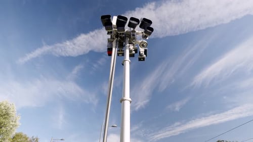 Close Up of a Cluster of Security Cameras Mounted Against a Clear Blue Sky