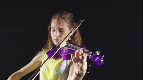 Woman Plays a Purple Violin on Black Background