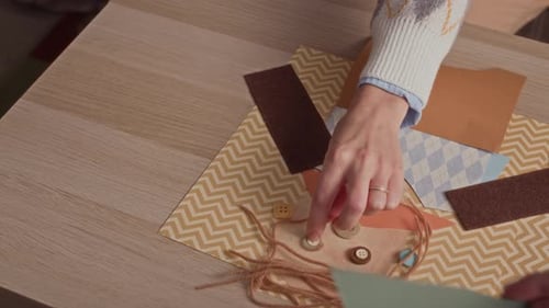 Hands of Family Making Collage on Paper when Crafting at Table Indoors