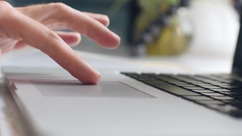 Close Up Shot of Man's Hand Scrolling a Website Using Laptop Track Pad