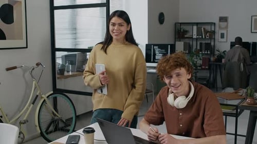 Portrait of Two Positive Diverse Young Coworkers during Workday in Office