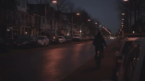 Late evening night street view on Jan Pieterszoon Coenstraat with incoming and going traffic and a w