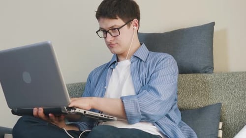 Young Adult Typing on Laptop at Home