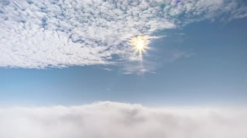 Aerial drone view of the sky with clouds and bright sun
