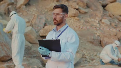 Serious Ecology Expert Man Stand Writing in Protection Wear Working on Land Relief Chemicals and