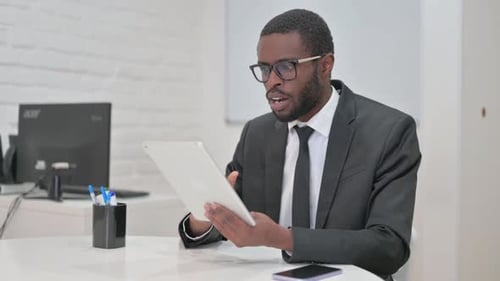 Excited Man Celebrates Good News on Tablet at Desk