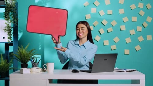 Young Woman Presenting a Speech Bubble in Office
