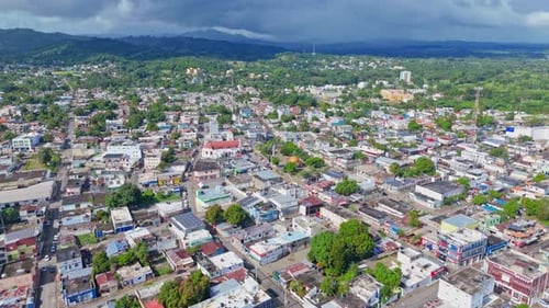 Aerial view of Cotui Cityscape with Tropical trees and colored roofs at daytime. Main street.