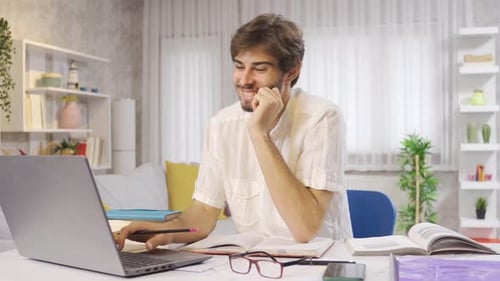 Young Adult Celebrates Success at Laptop Indoors