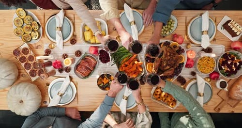 Festive Friends Clinking Wine Glasses at Thanksgiving Dinner