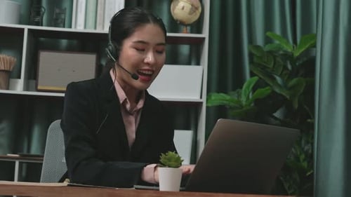 Woman in Headset Working Remotely at Desk