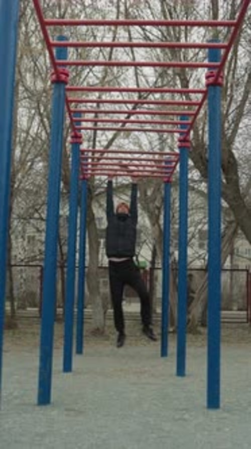 Coach Swinging on Iron Bar with Urban Park and Football Scene in Background
