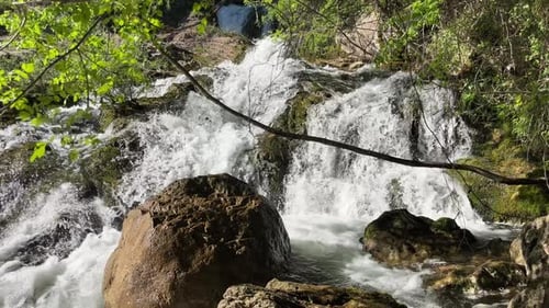 Une puissante cascade s'écoule sur de gros rochers