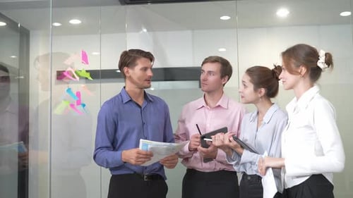 Business Team Discussing Ideas at Office Glass Board
