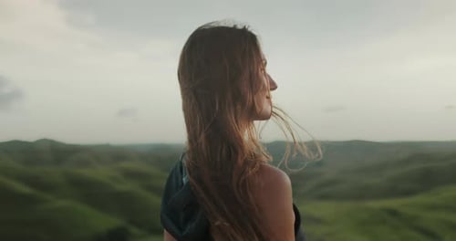 Female Enjoy Green Hills Landscape at Sunset