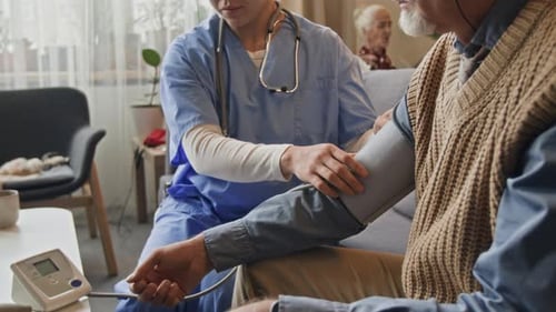 Nurse Measures Blood Pressure of Senior Man at Home
