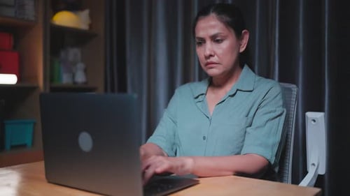 Woman Working On Laptop at Night Indoors