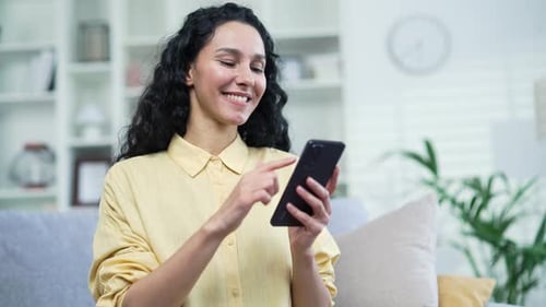 Woman Smiling Using Mobile Phone Indoors