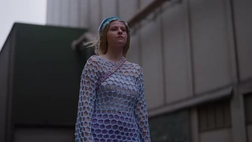 Young Woman Walks Through Urban Industrial Area