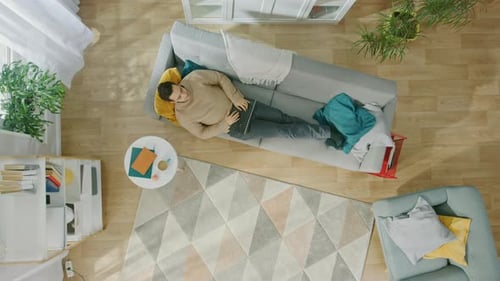Man Relaxing on Couch Using Laptop, Bird's Eye View