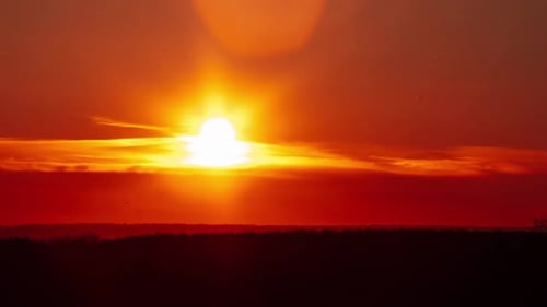 Sunset Above the Horizon in Orange Sky With Soft Clouds Timelapse