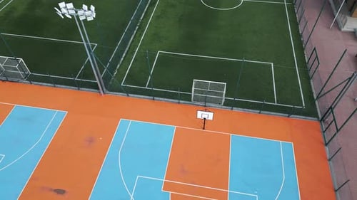Aerial View of Outdoor Basketball and Soccer Courts with Vibrant Blue Orange and Green Colors The