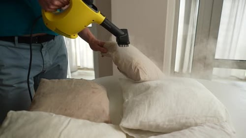 Person Steaming Pillows in a Sunny Home