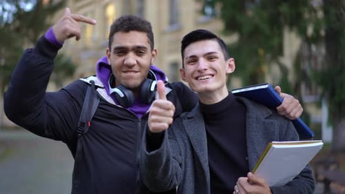 Aufgeregte junge Männer gestikulieren Daumen hoch, lächeln, sprechen in die Kamera, Frontansicht, Porträt von