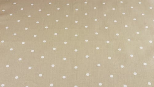 Top view of the lovender grey with white polka dots cotton fabric rotated on the display case.