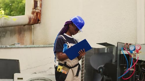 HVAC Technician Inspecting Air Conditioning Unit