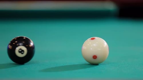 Billiard pool table shows black eight ball arranged for game play, is hitting by the white cue ball