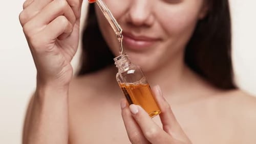 Woman with Golden Liquid and Pipette Close Up