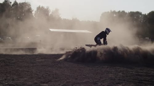 Motorcyclists in Helmet Skids on Bike in Dust Clouds on Field