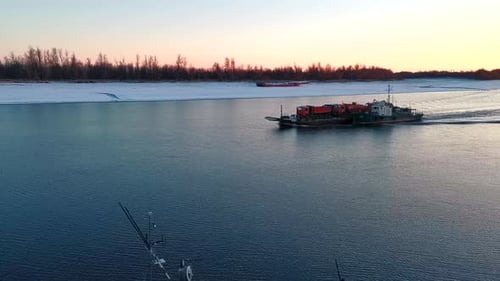 View of cargo boat floating on river in winter