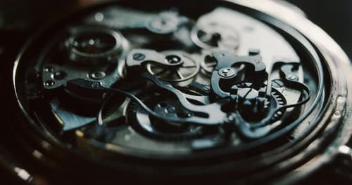 Slow motion close up of a professional watchmaker repairer working on a luxury mechanism watch gea