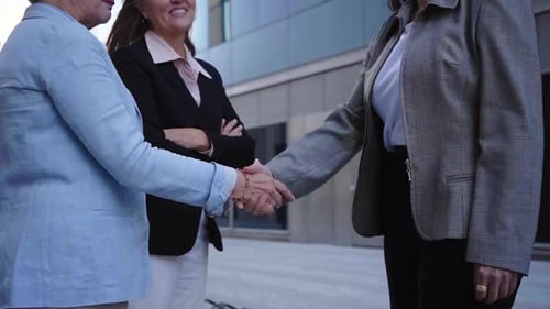 Businesswomen Shaking Hands Finalizing a Successful Deal Outside a Modern Office Building