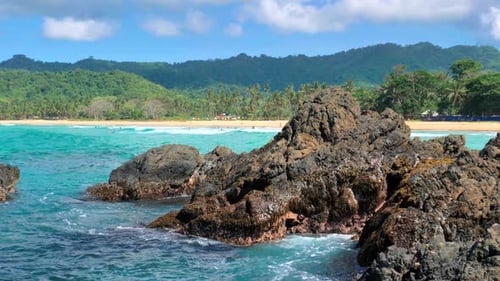 Waves Beat Against Big Rocks in the Ocean with Clear Water Concept of Nature